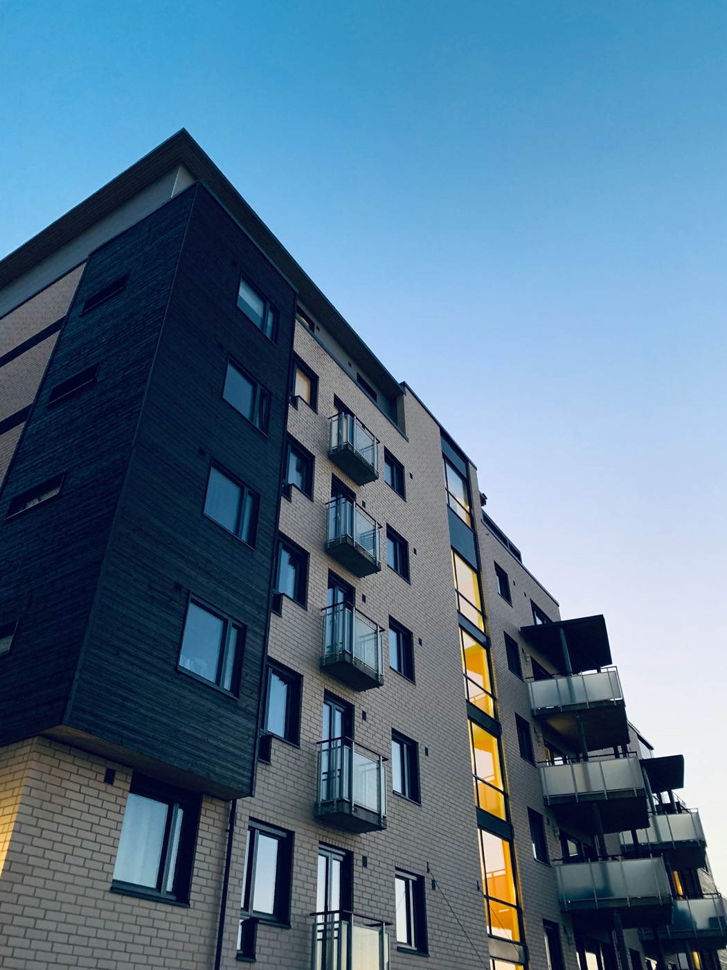 Fachada de predio residencial vista de baixo, no fim da tarde